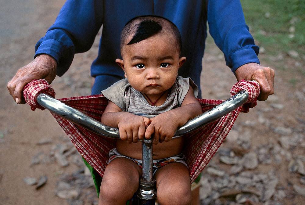Steve McCurry, Baby in a Bicycle Sling, 2000
FujiFlex Crystal Archive Print, (Inquire for available sizes)
CAMBODIA-10082NF2