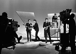 black and white photograph of the Beatles performing on the Ed Sullivan Show in 1964